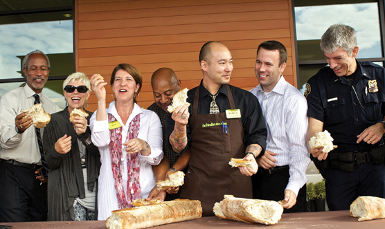 New Seasons CEO Wendy Collie (third from left) joins store staff and local community leaders at a ‘bread-breaking’ celebrating the chain’s newest store opening  in Portland, Ore.