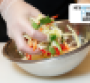 A chef hand mixing a salad (1).png