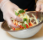 A chef hand mixing a salad.png